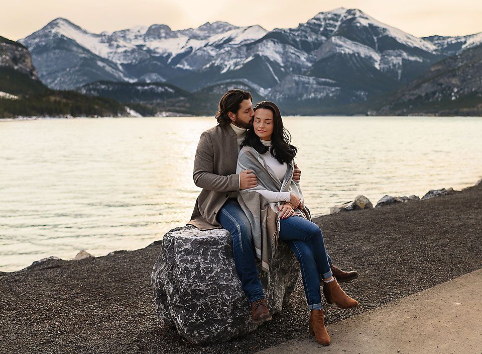 Young couple posing near water at Barrier Lake, Canmore, Alberta