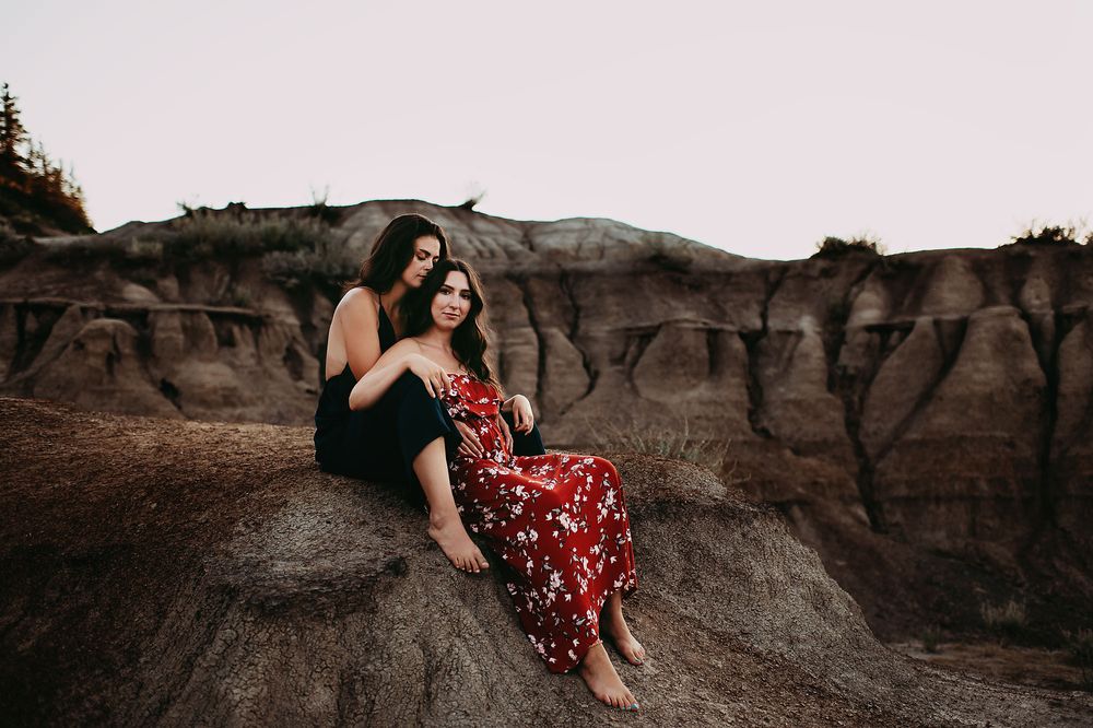 Young lesbian couple sitting on a rock in Drumheller, Alberta