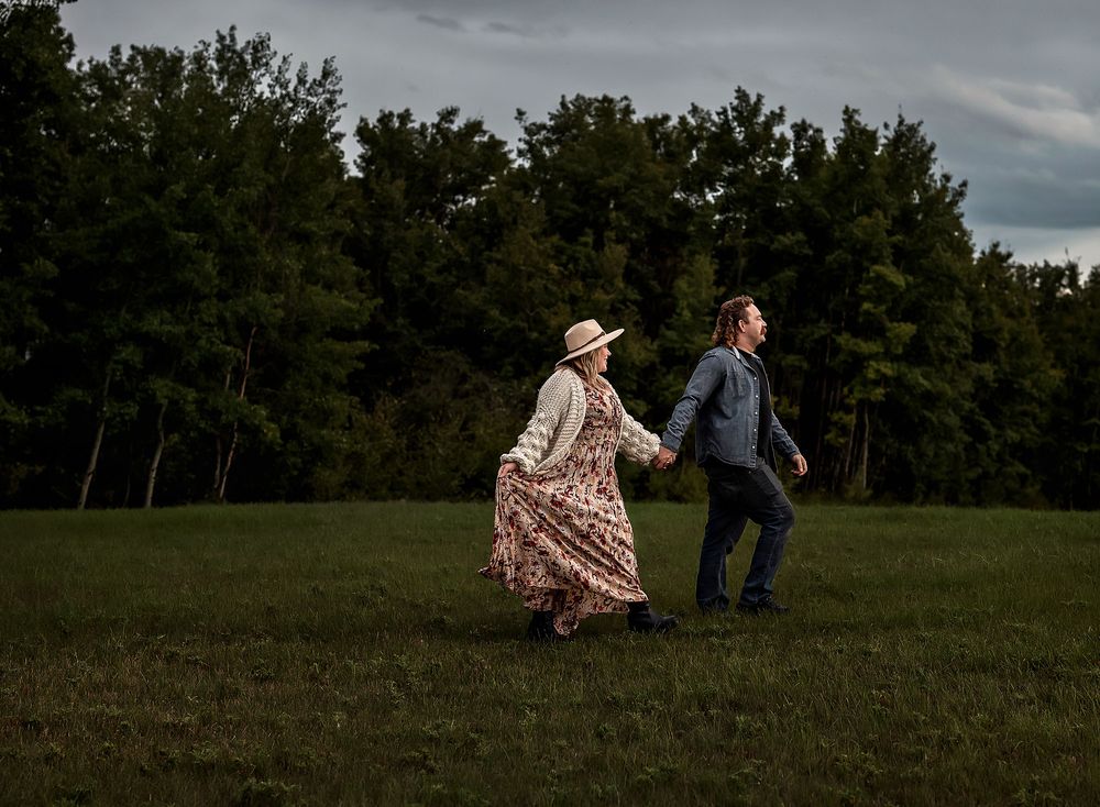 Man holding girlfriends hand walking in forest in Airdrie,  Alberta
