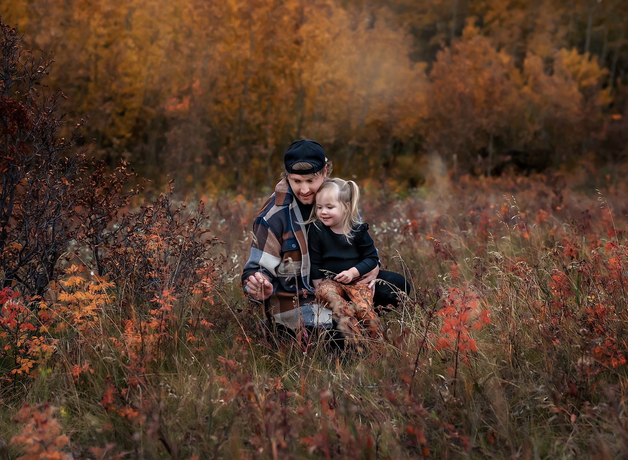 Dad and his little girl looking at a leaf in Nose Hill Park, Calgary, Alberta
