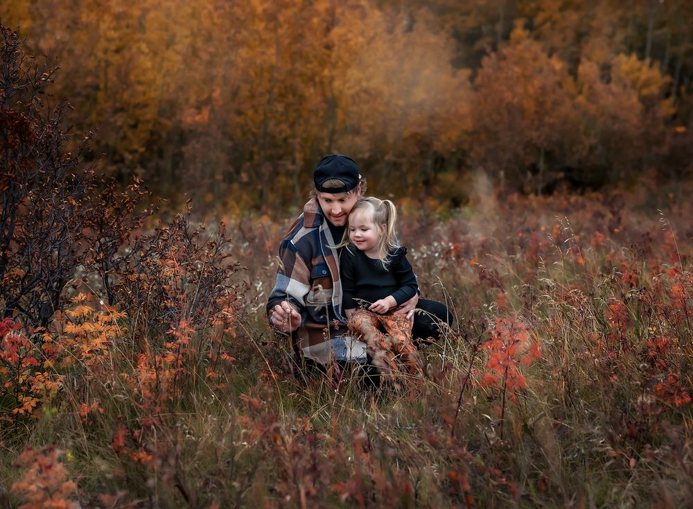 Dad and his little girl looking at a leaf in Nose Hill Park, Calgary, Alberta