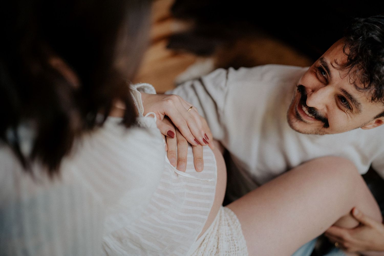 Intimate close-up portrait of affectionate couple laughing together while lying down.