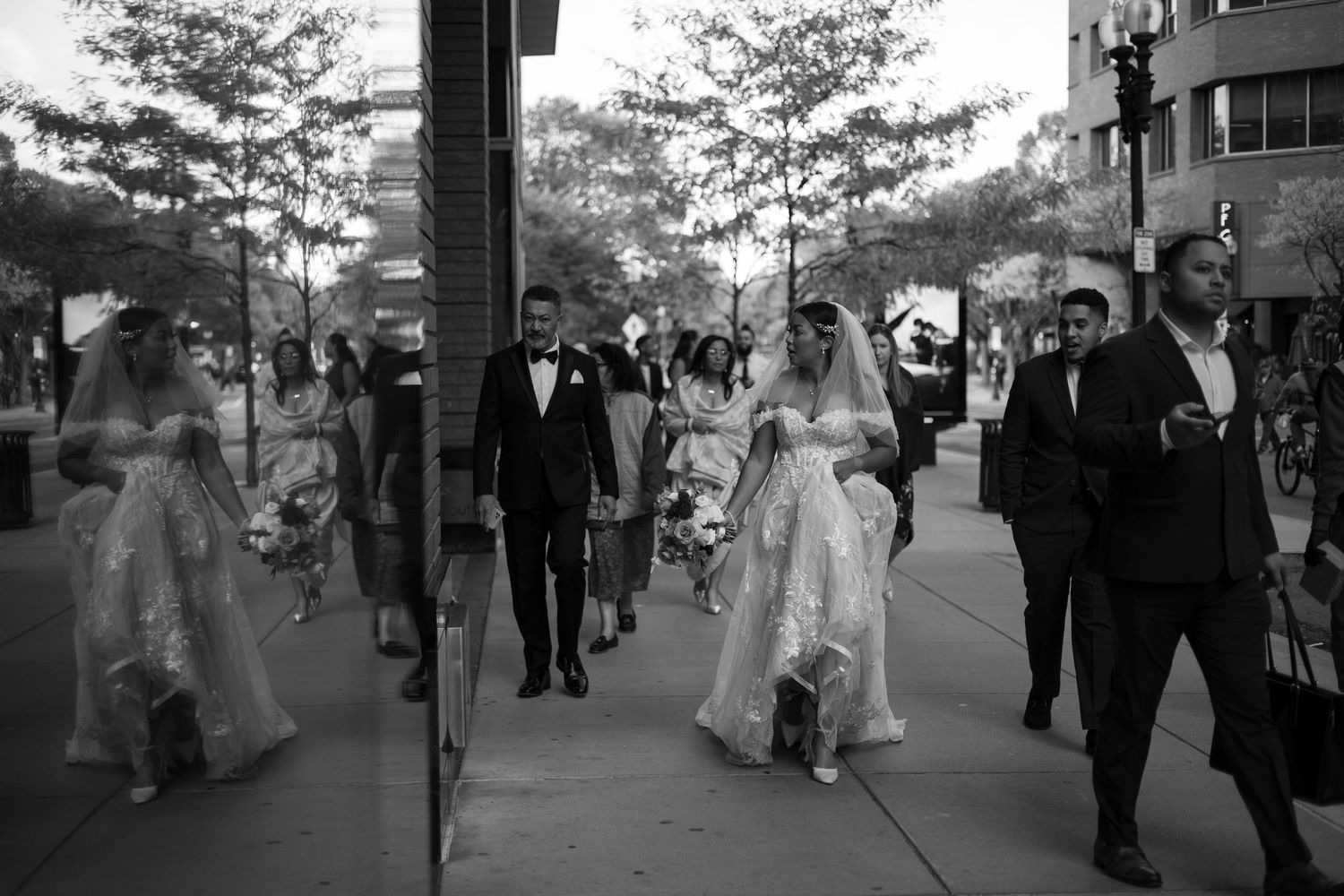 A sequence of black and white wedding photos showing a couple walking through a crowd of guests outdoors.