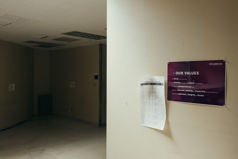 Long corridor with cream colored walls and directional signage.