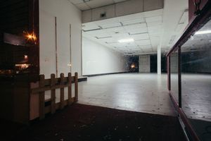 Empty industrial warehouse space with exposed ceiling and concrete floors.
