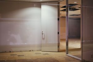 Dimly lit commercial space with dark walls and exposed ceiling elements.