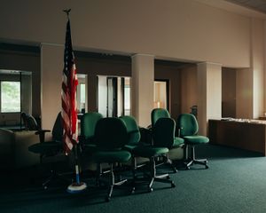 Office space with green chairs and American flags arranged along the wall.