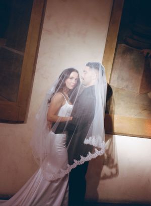 Dreamy, artistic wedding portrait with soft lighting and flowing veil.