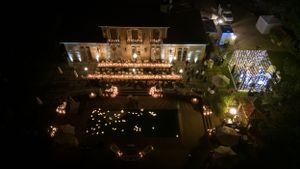 Elegant mansion venue illuminated at night with decorative lights and landscaping creating a romantic atmosphere.
