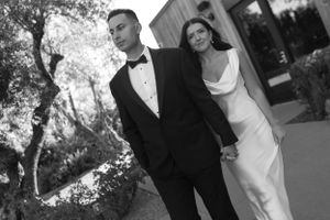 Classic black and white wedding portrait against architectural backdrop.