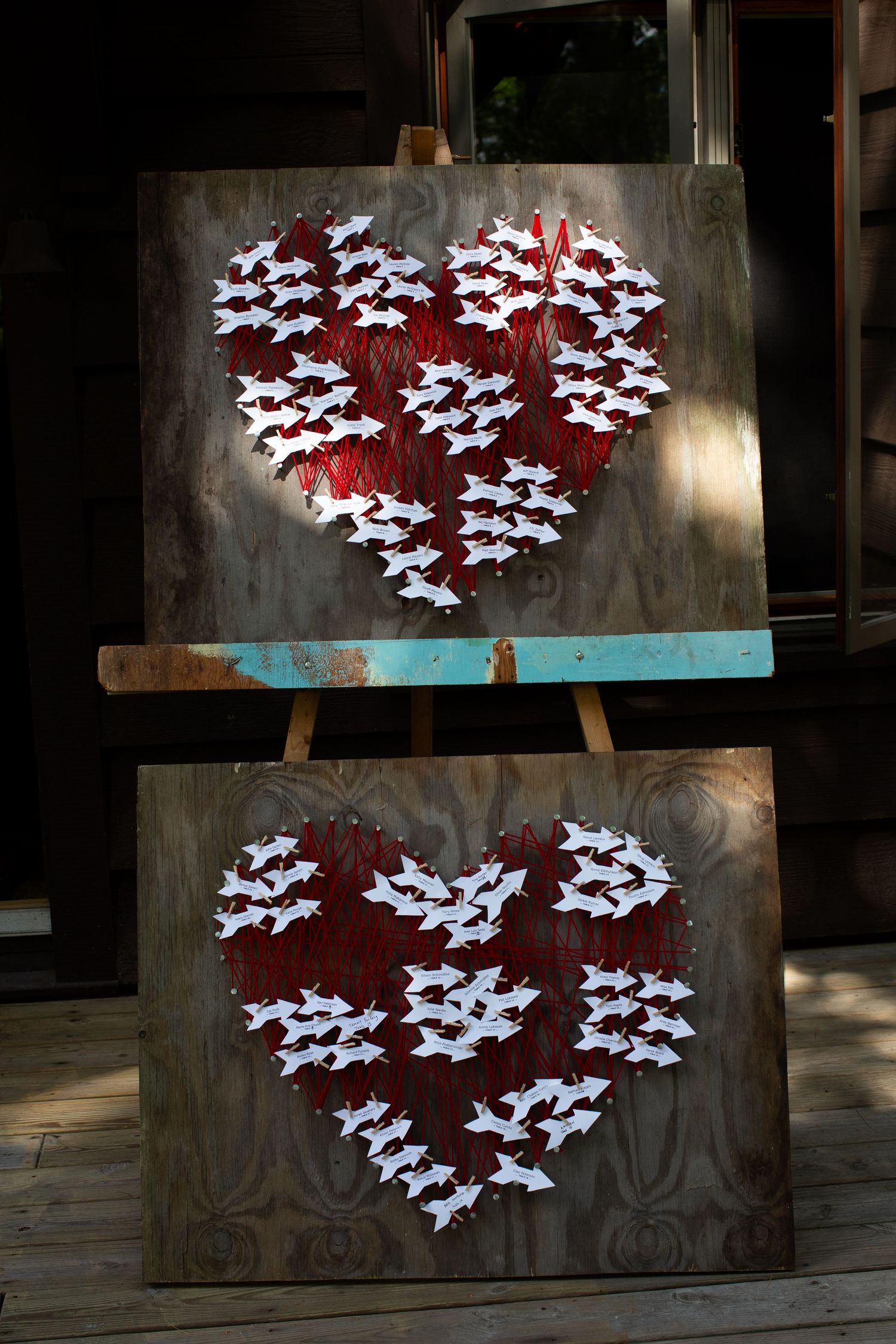 A series of white butterfly silhouettes arranged in heart shapes against a dark wooden background create an artistic display.
