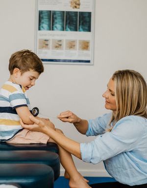 A physical therapy session shows therapeutic manipulation techniques being performed on a treatment table.