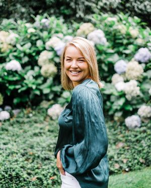 A joyful moment captured in a garden with blooming white hydrangea bushes and greenery in the background.