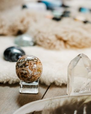 Crystal healing stones and quartz points arranged on a textured beige surface with shallow depth of field.