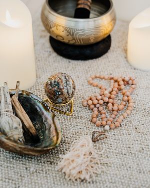 Himalayan singing bowls and pink salt crystals arranged on a textured linen surface create a peaceful meditation setup.