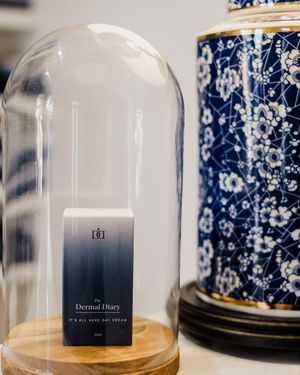 A series of glass bell jars displayed in a row with decorative blue and white porcelain patterns visible in the background.
