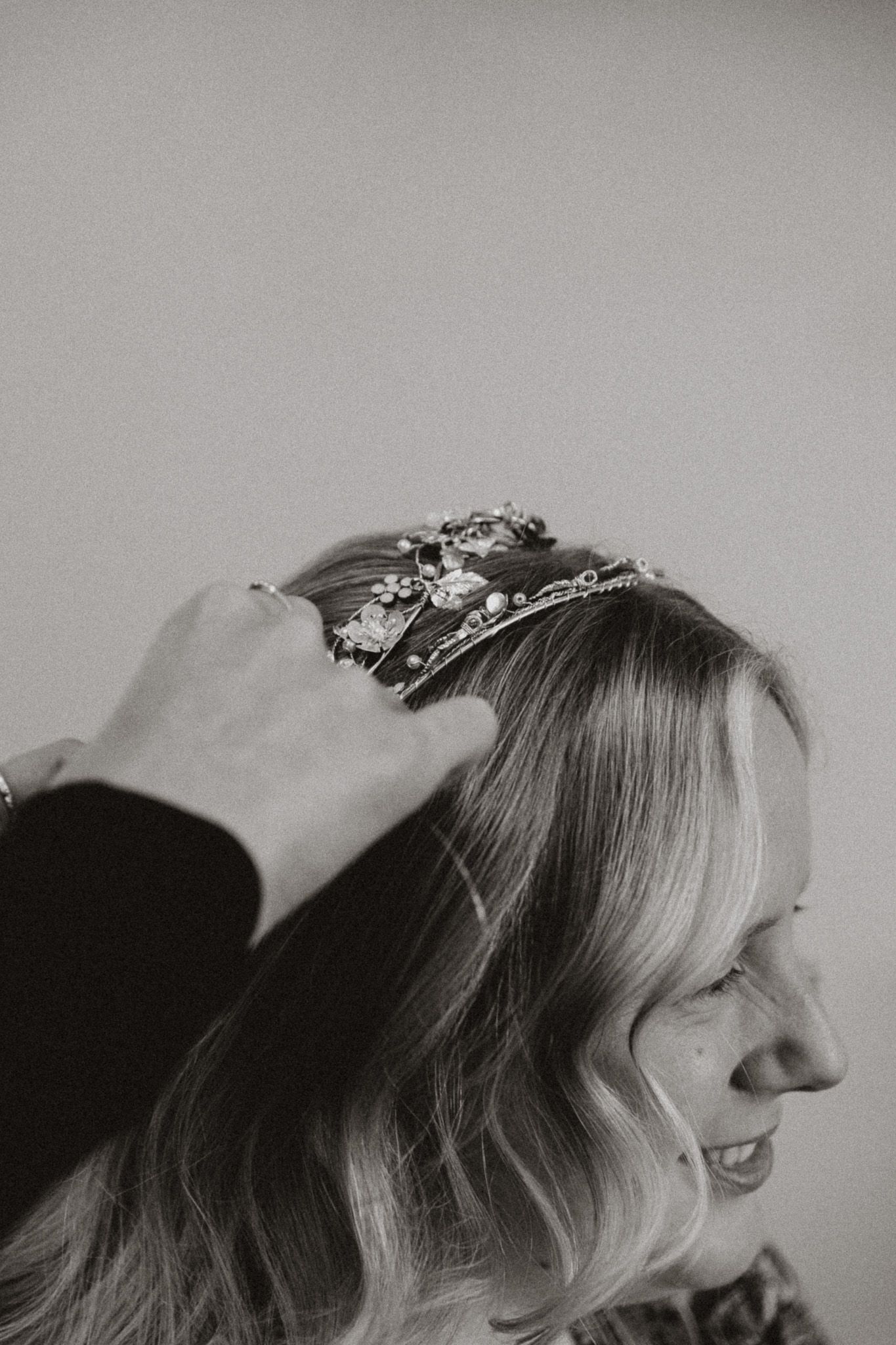 A series of black and white profile shots showing a person wearing a delicate floral crown against a light background.