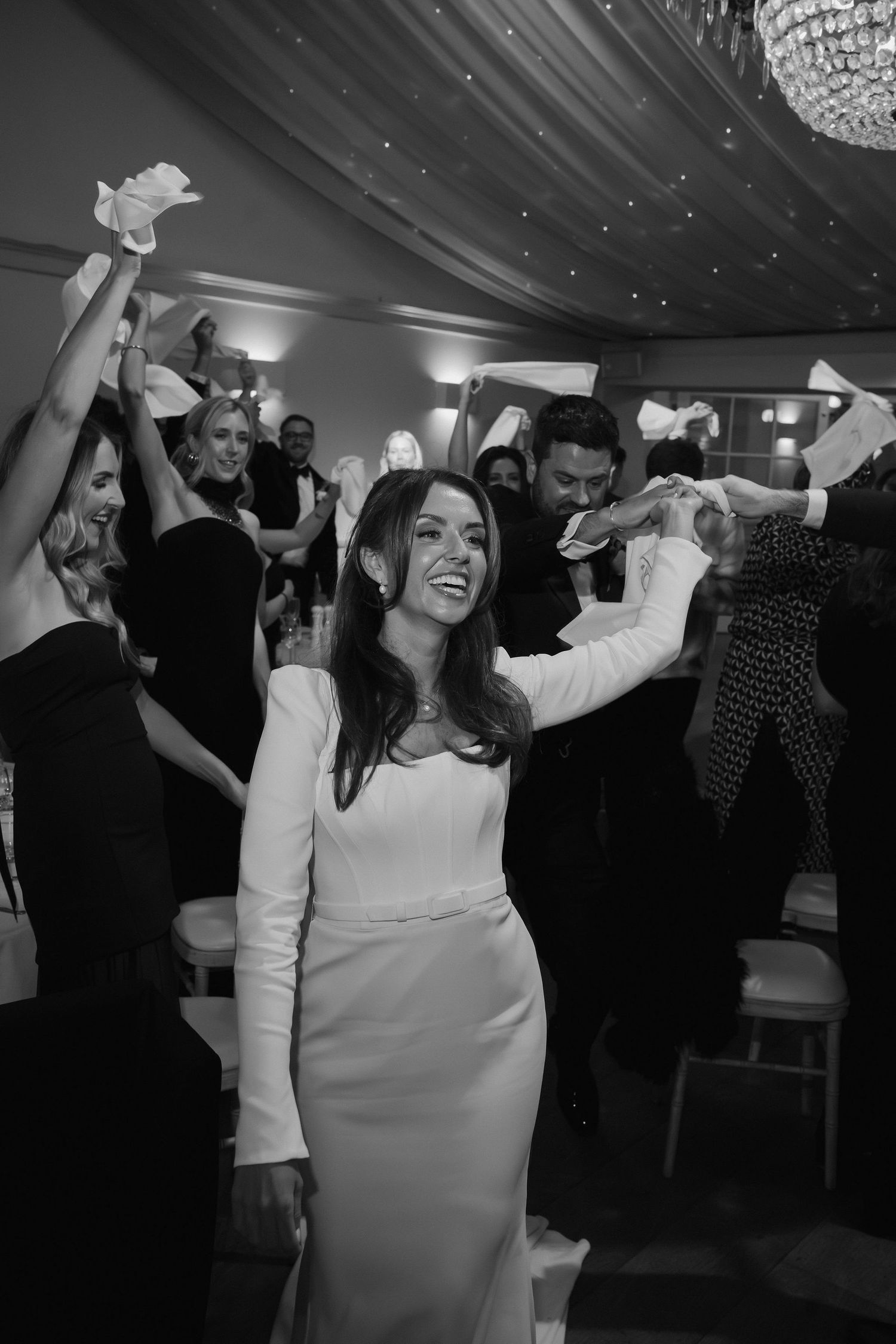 bride and groom entering wedding breakfast surrounded by guests cheering and waving napkins at Iscoyd park