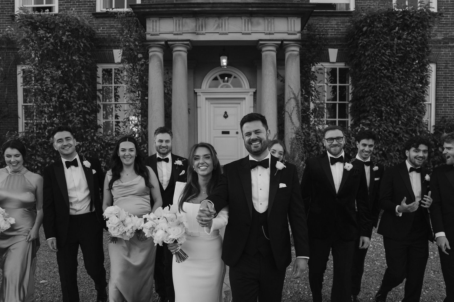 bride and groom and wedding party walking and talking, laughing outside Iscoyd park
