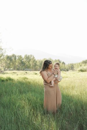 A tender moment shared between two people in a sun-drenched meadow with tall grass and golden light.