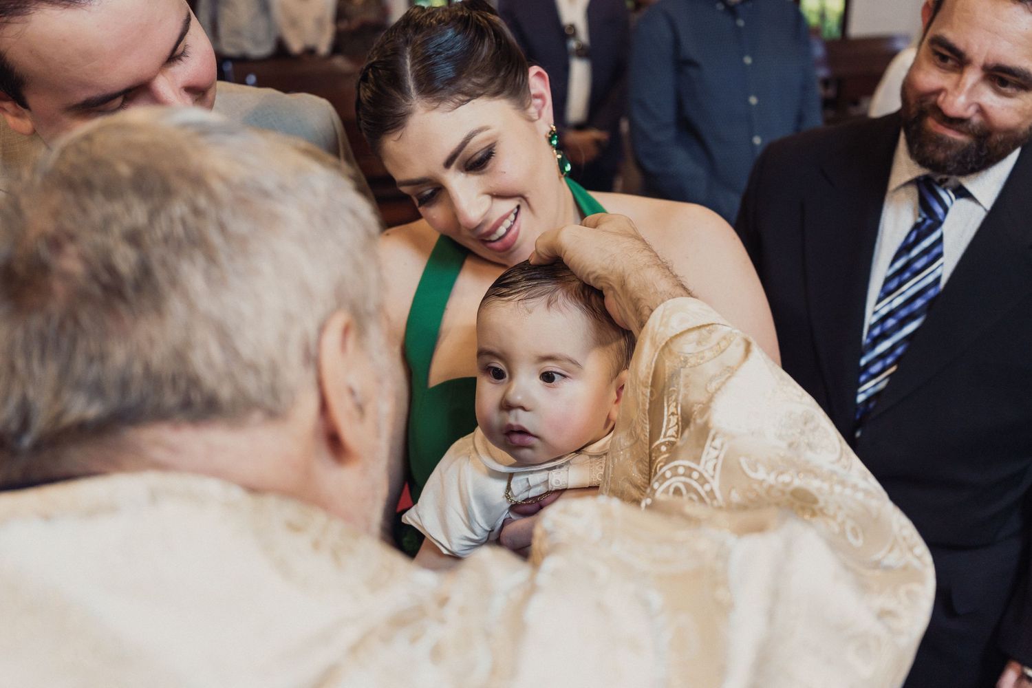 A couple shares a tender moment during their wedding celebration while guests look on and smile.