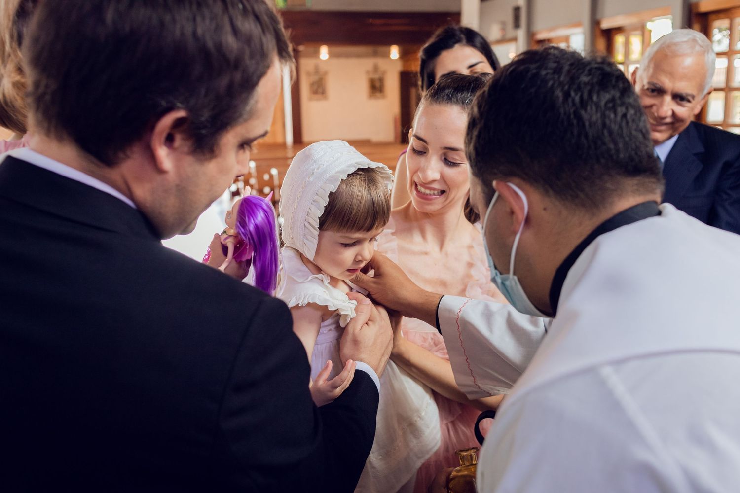 A group of wedding guests dance and celebrate together on a dance floor at an indoor reception.