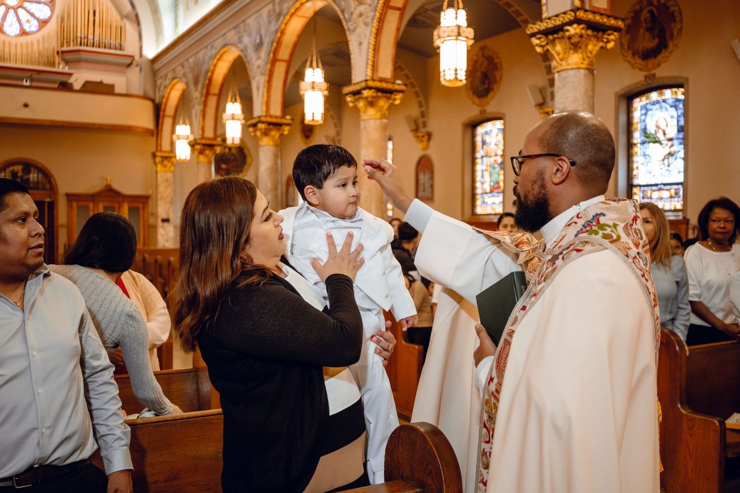 Guests celebrate and dance together during a joyous wedding reception in an elegant church hall with arched ceilings.