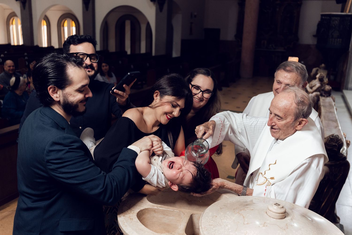 A group of people share a joyful moment together at a table during what appears to be a social gathering.