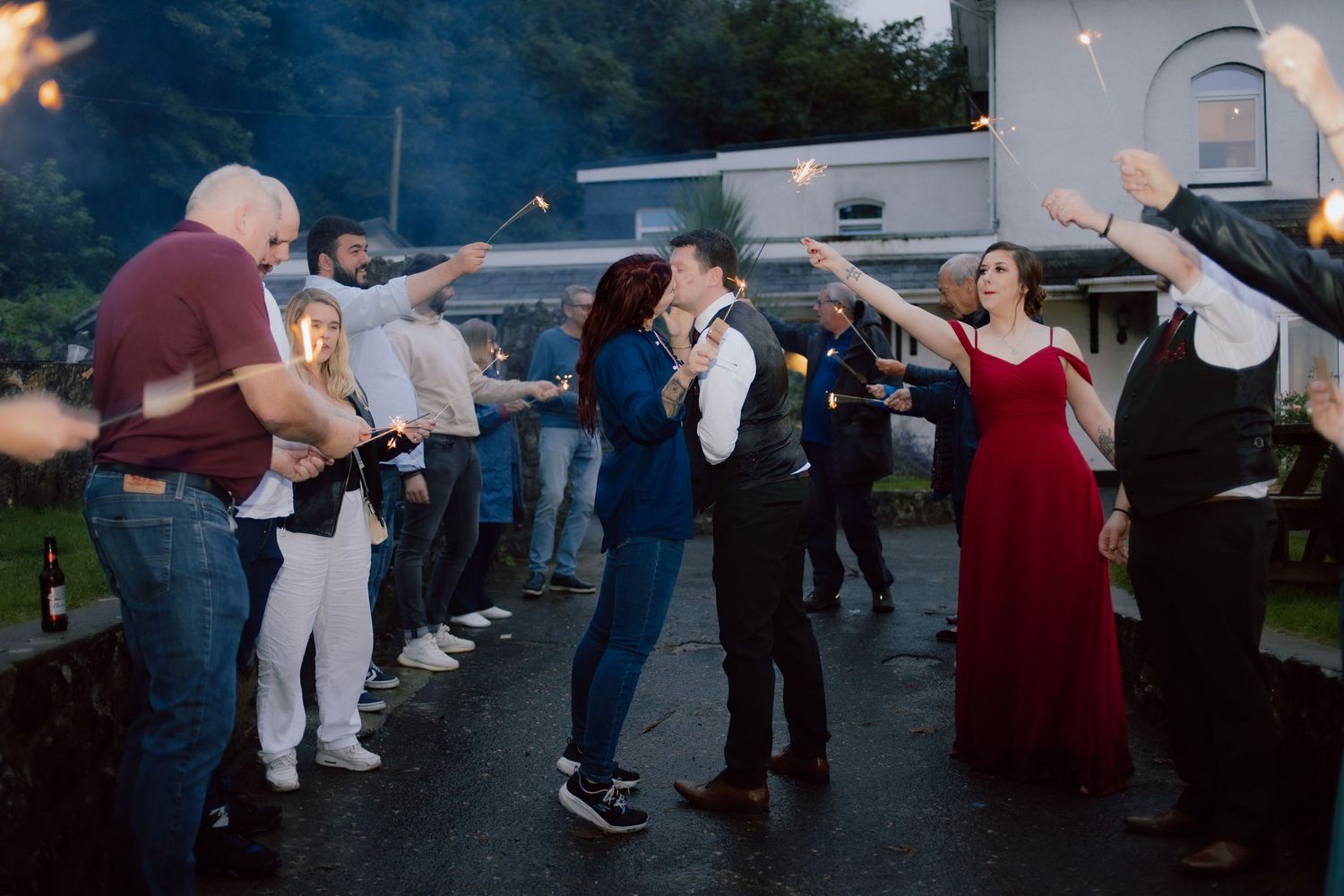 A group of people dancing together in a line at an outdoor evening event.