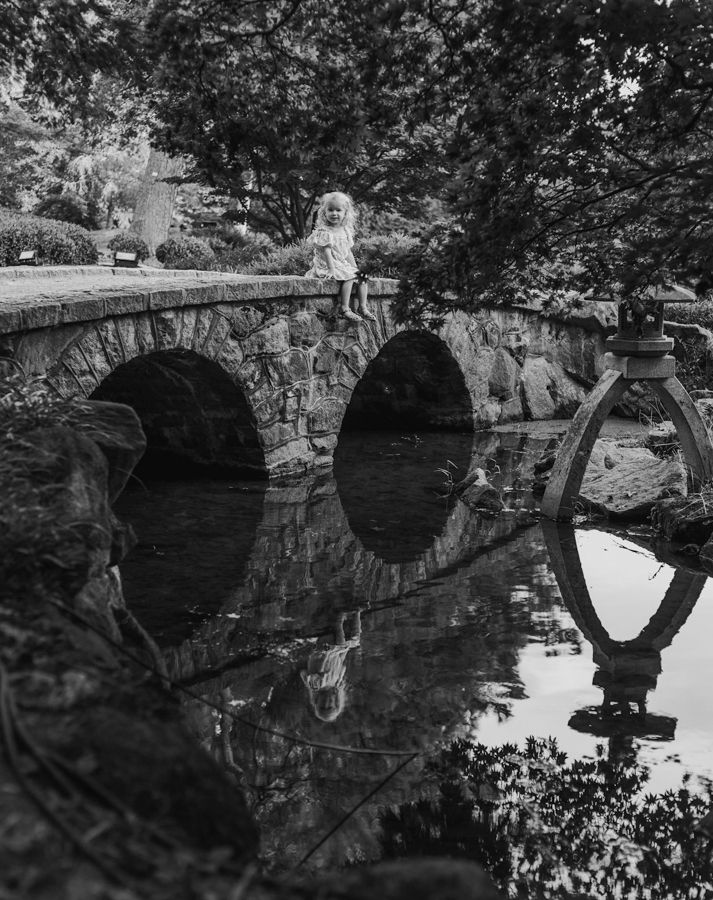 little girl sitting on a japanese bridge in maymont park rva