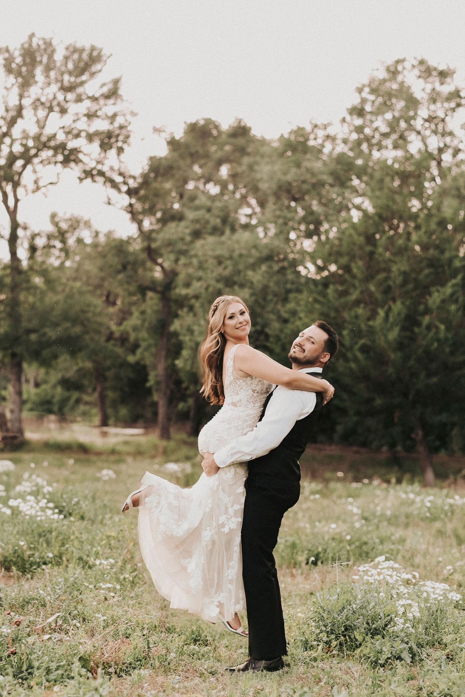 Bride and groom walking together during golden spring light at their outdoor wedding.