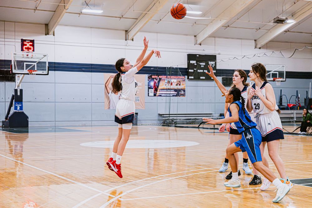 Girls Basketball player shooting a three pointer