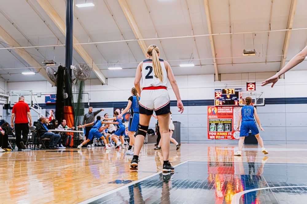 Girls Basketball player facing away from camera looking towards her teammates