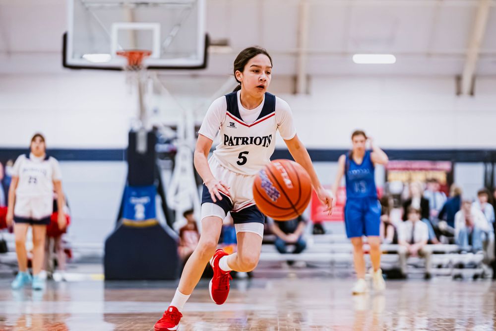 Girls Basketball player dribbling the ball towards the camera