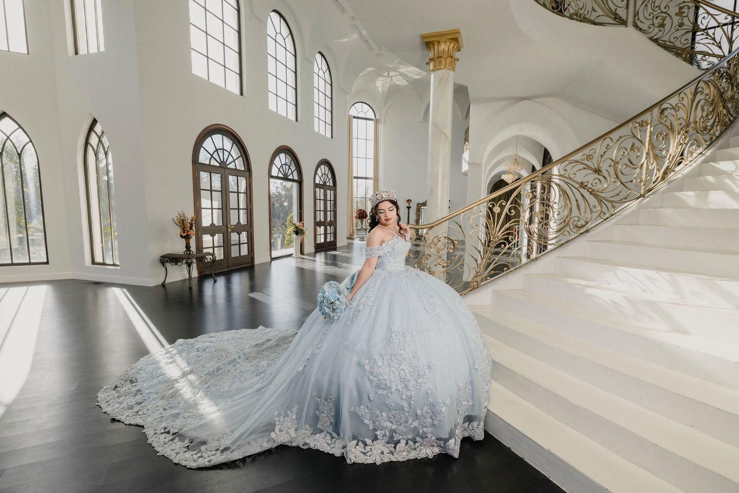 A stunning white wedding dress with a flowing train and veil displayed in an elegant church interior.