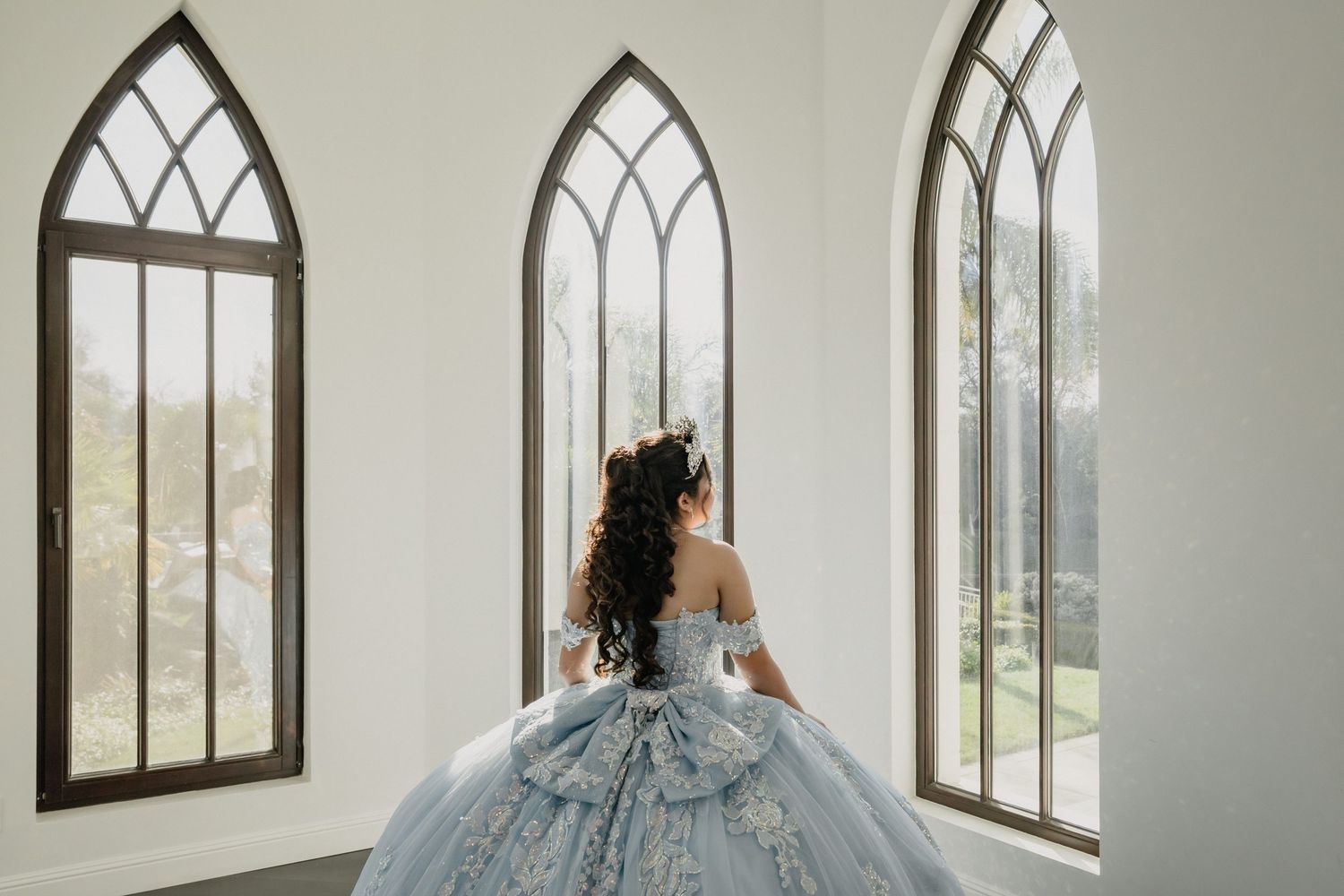 Ethereal bridal portrait with Gothic arched windows in bright white chapel interior.