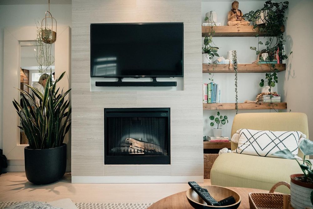 Modern living room features white brick walls, floating shelves, and a sleek electric fireplace with contemporary decor.
