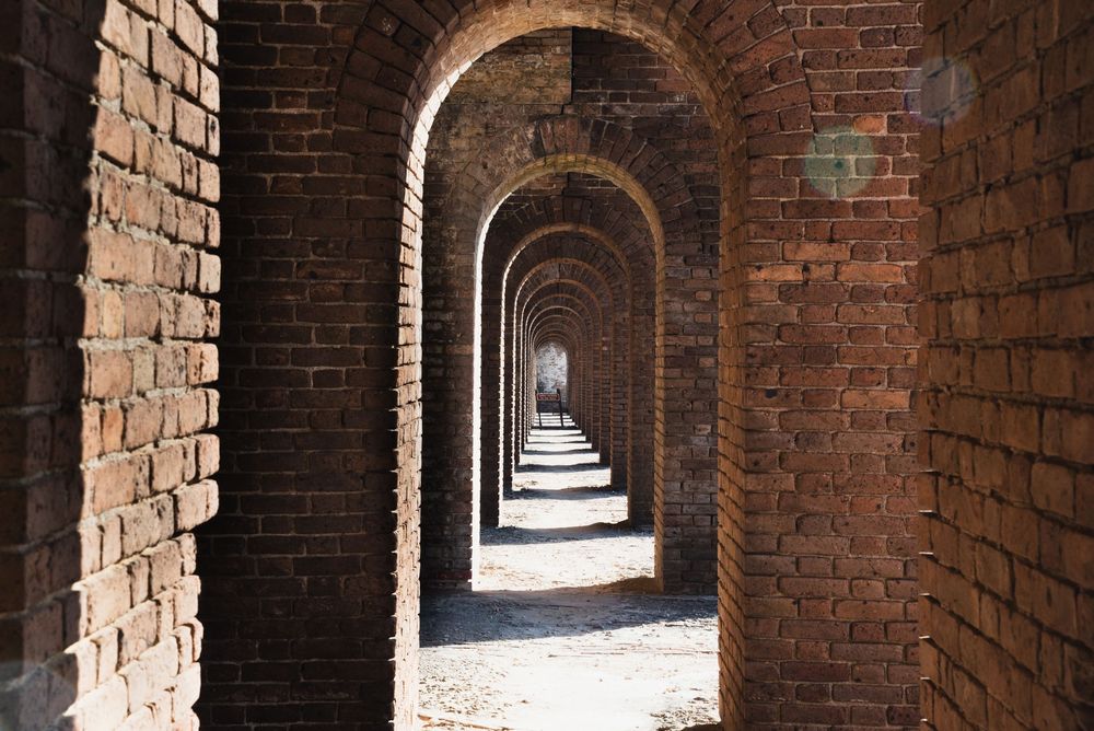 A long corridor of repeating brick archways creates a dramatic sense of depth and symmetry.