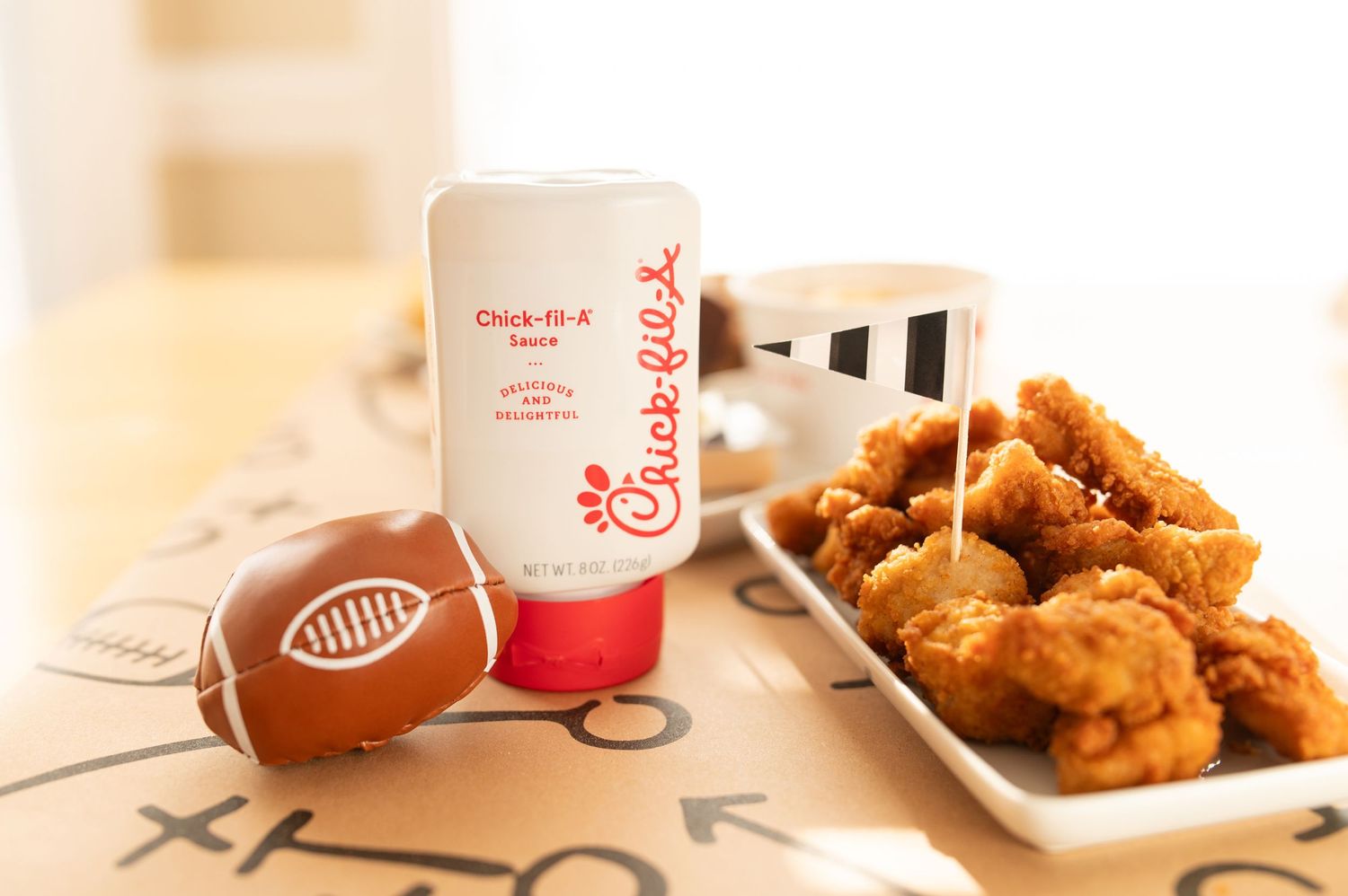 Crispy chicken nuggets served alongside Chick-fil-A branded cups on a wooden table.