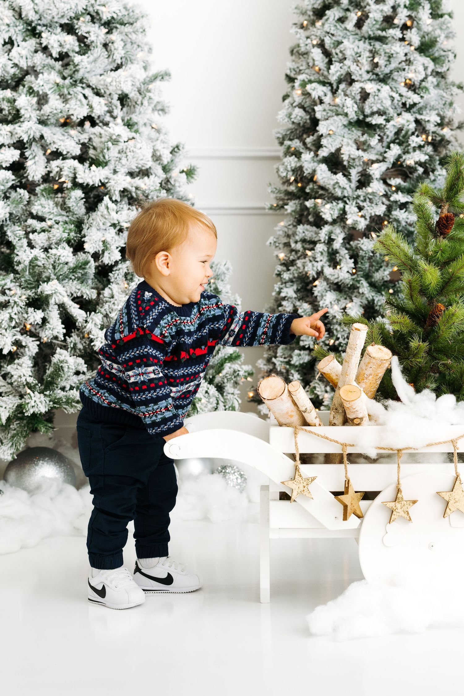 festive wagon filled with hand cut Christmas trees for toddler and baby