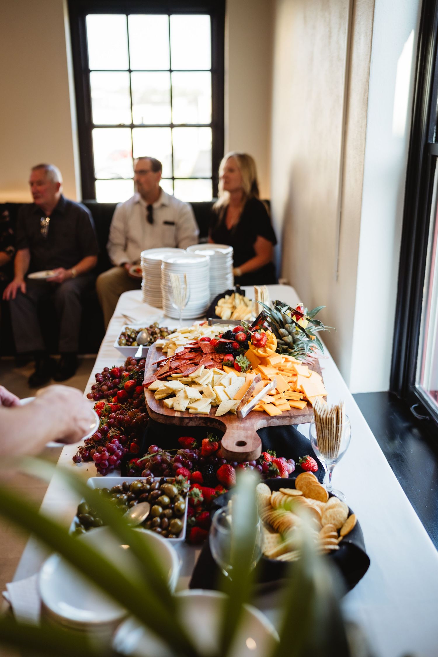 Elegant buffet table with charcuterie boards and appetizers displayed at an indoor event venue.