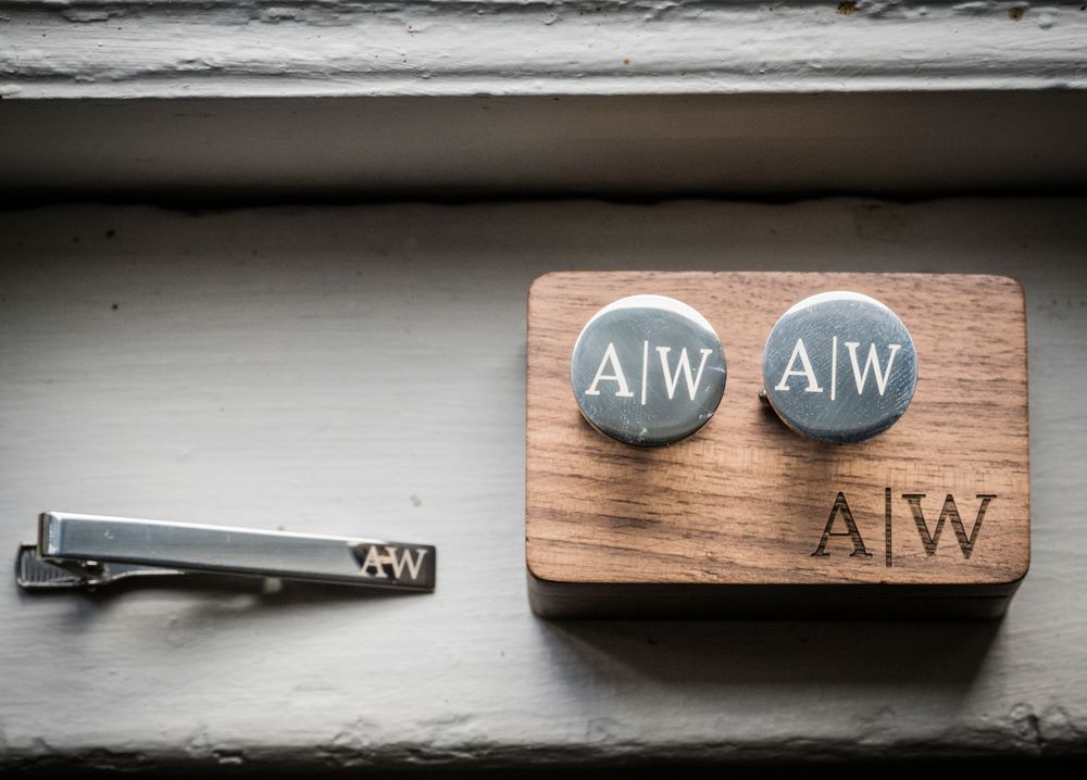 Wooden wedding decor pieces featuring 'AIW' monogram displayed on dark textured surface.
