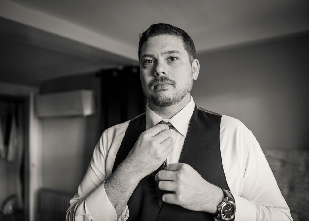 Black and white portrait series of groom getting ready on wedding day.