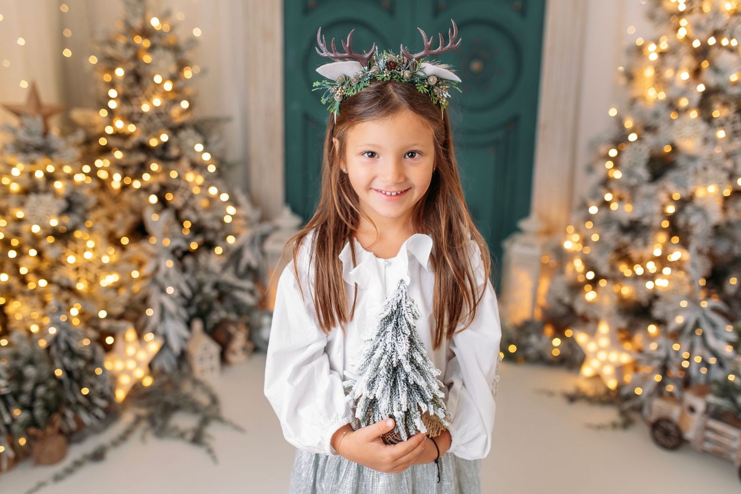 A series of holiday photos with a silver Christmas wreath and glowing Christmas trees in the background.