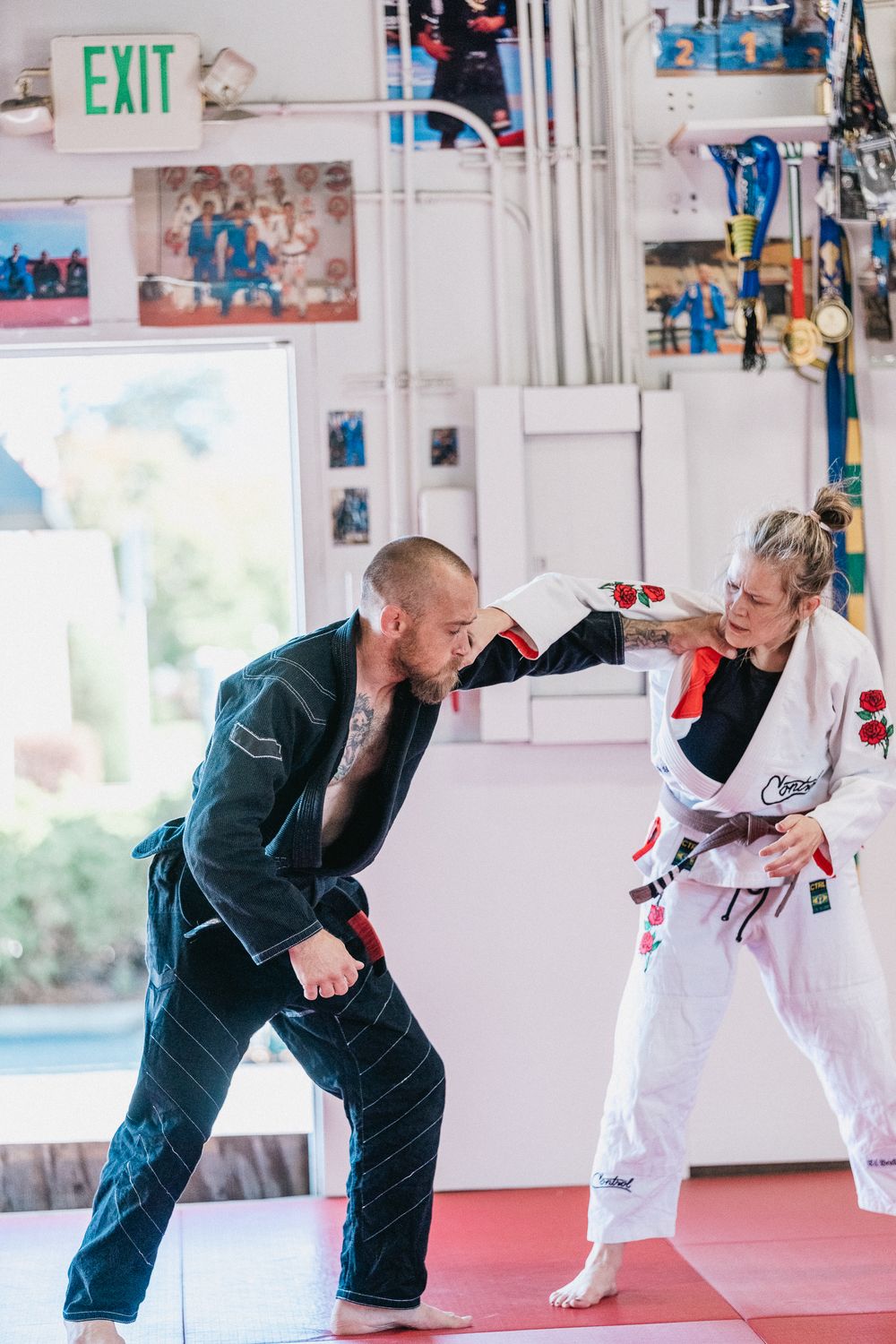 Martial arts instructor demonstrates a spinning kick technique during a training session in a bright studio.