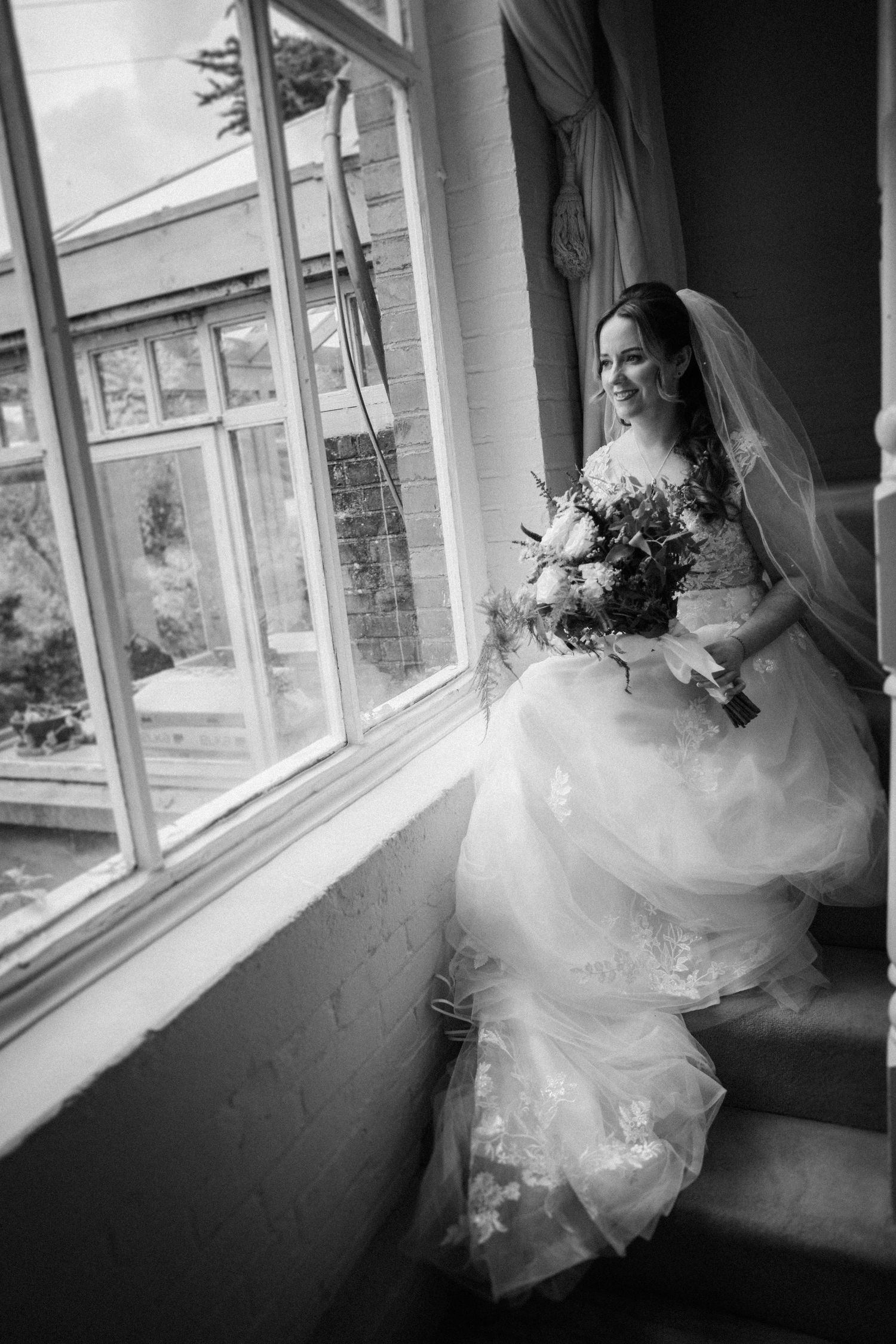 Black and white photos capture a bride's dress flowing by sunlit windows.