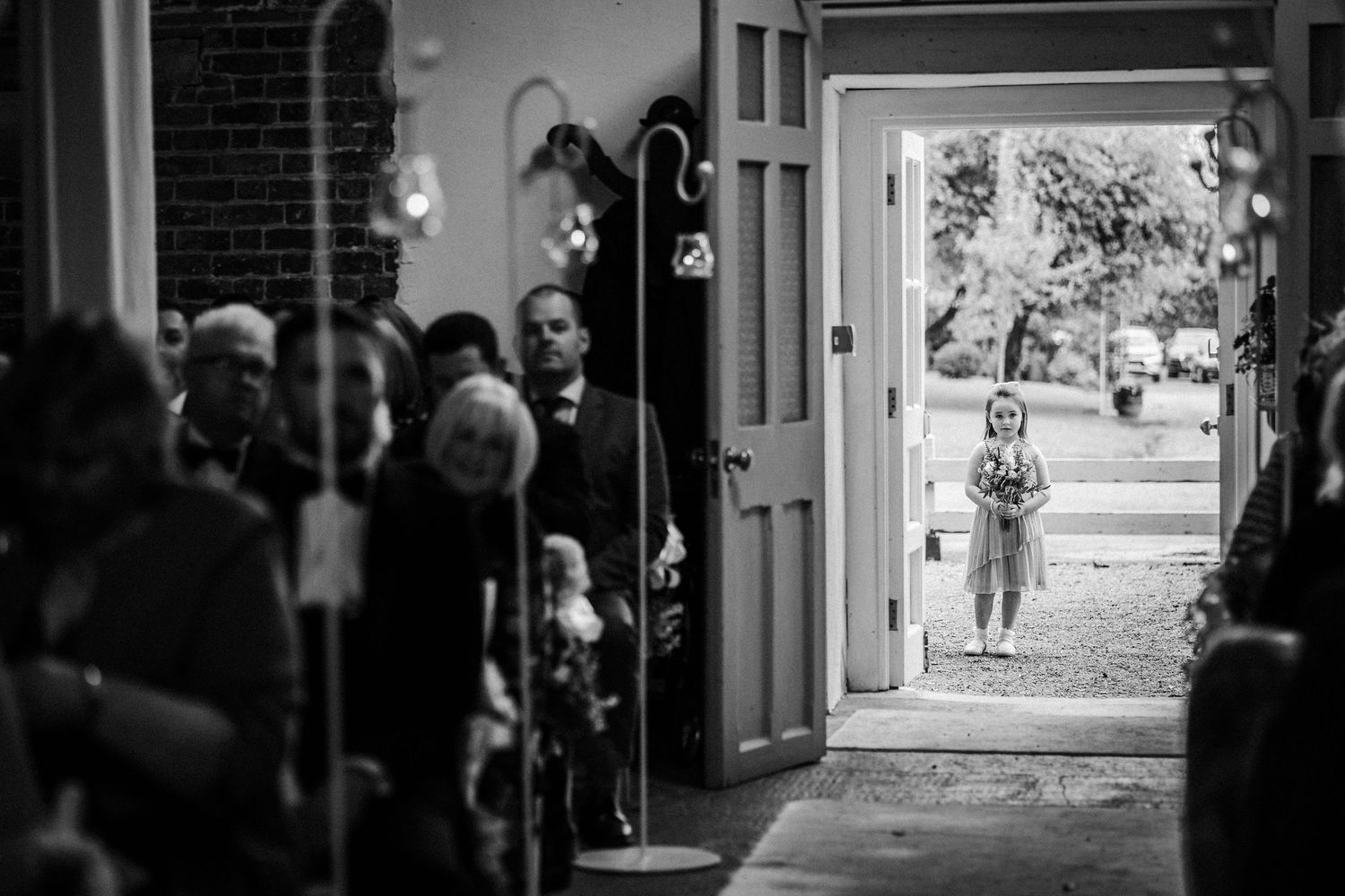 Black and white photos showing a wedding party walking through doorways and corridors of a historic building.