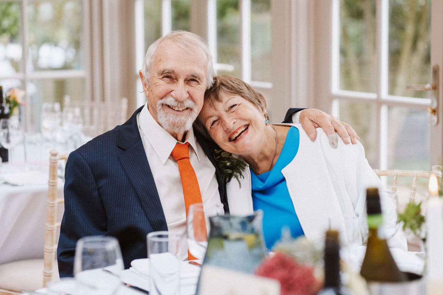 Wedding celebration scene with bright orange and blue accents in an elegant indoor setting.