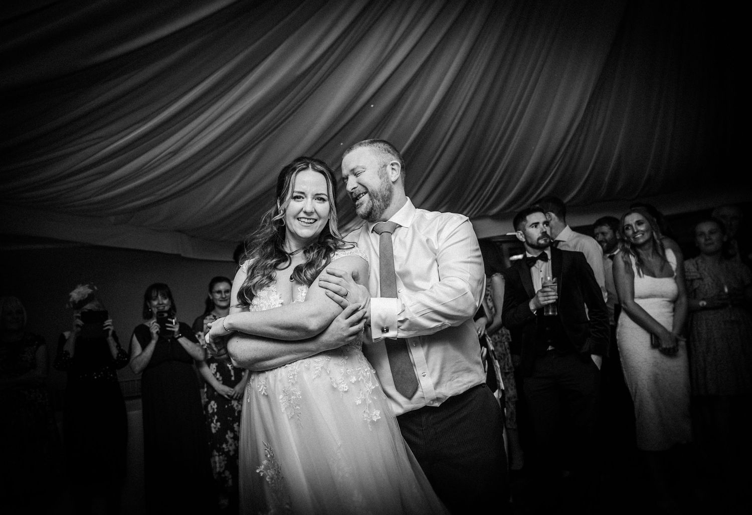 Black and white wedding reception photos showing couples dancing and embracing on the dance floor.