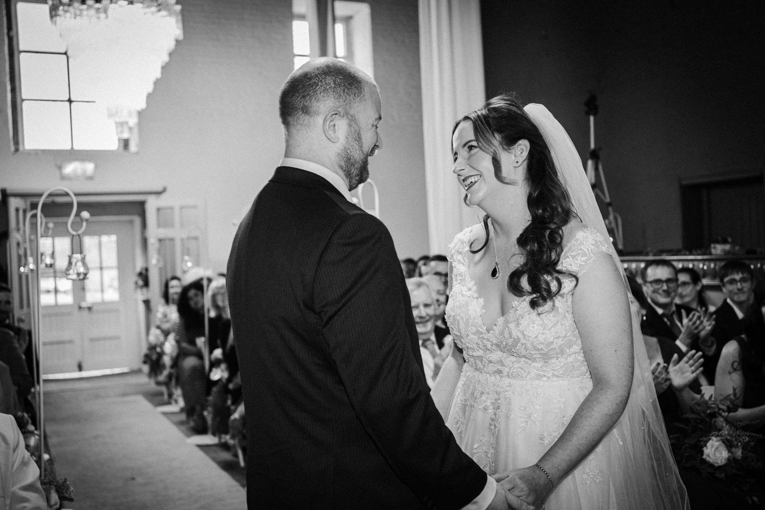Black and white wedding photos showing intimate moments during a celebration in an elegant indoor setting.